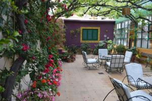 a patio with chairs and flowers and a purple building at Hotel Mallorca in Mendoza