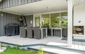 a patio with chairs and a table on a house at Lovely Home In Juelsminde With Kitchen in Sønderby
