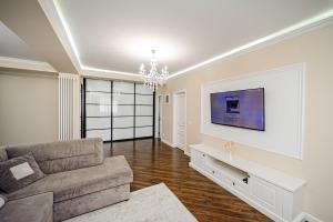 a living room with a couch and a tv at Elegant stay near the Park in Chişinău