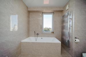a large bathroom with a tub and a window at Elegant stay near the Park in Chişinău +46 photos