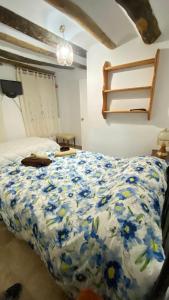 a bedroom with a bed with a blue and white comforter at Apartamento Nanda in Quesada
