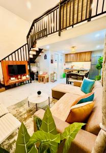 a living room with a couch and some plants at Tagaytay's Cozy Loft-type Forest House and Camp in Silang +48 photos
