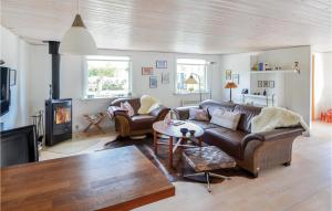 a living room with a leather couch and a fireplace at Two-Bedroom Holiday Home In Hornslet in Hornslet +15 photos