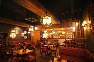 a restaurant with tables and chairs and lights at Imperial Heights in Deoghar