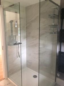 une douche avec une porte vitrée dans une salle de bain dans l'établissement Cottage with Heated Indoor PoolTennis Court- 2142, à Farnham