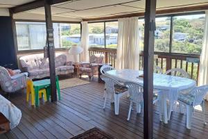 a living room with a table and chairs on a deck at Jolly Mooi's Beach Break in Gxara