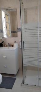 Un baño con ducha de cristal y lavabo. en Casa Vistabella, en Costa Calma