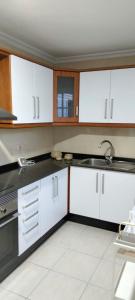 Una cocina con gabinetes blancos y un fregadero. en Casa Vistabella, en Costa Calma 26 fotos más