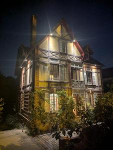 a large house is lit up at night at Au Bonheur des Voyageurs, 30' de Paris in Villennes-sur-Seine