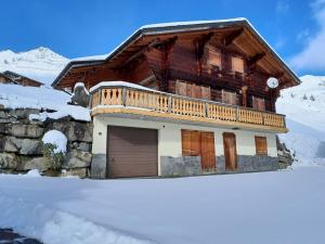 a wooden house with a balcony on top of snow at Le Pacheu in Les Crosets