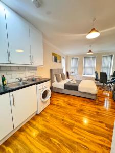 a kitchen and living room with a bed in a room at Comfort Heathrow Stay 5 Mins to the Terminal in Stanwell