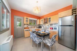 une cuisine avec une table avec des chaises et un réfrigérateur dans l'établissement Villa Amore Sunrise by Villa Plus, à Agia Effimia