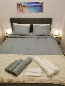 een bed met twee handdoeken en twee kussens erop bij GardenHouse in Athene