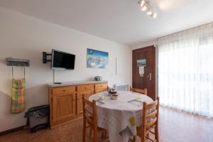 a dining room with a table and a television at Le Village des Thermes in Vignec