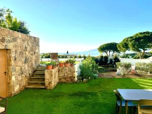 a garden with a stone wall and a table at Domaine LUMISTELLA in Porticcio