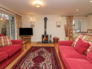 sala de estar con 2 sofás rojos y chimenea en Butterfly, en Kendal