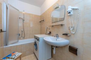 Un baño con lavabo y lavadora. en Appartamento Lucia 201, en Vigo di Fassa 23 fotos más