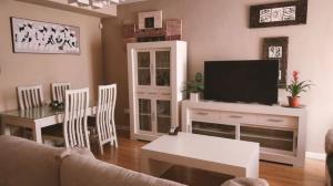 a living room with a couch and a tv and a table at Villalucen in Lucena