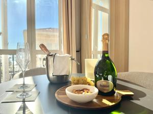 a bottle of wine and a bowl of food on a table at DELUXE SEAVIEW BALCONY - 2 min PALAIS & BEACH in Cannes
