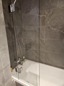 a bathroom with a shower with a glass door at Luxueux appartement de plage Surf & Golf Néroli 13 in Tamraght Ouzdar