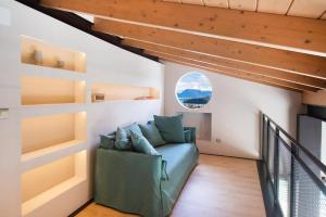 a living room with a green couch and a window at Villa Angelou Nidri by Villa Plus in Nydri