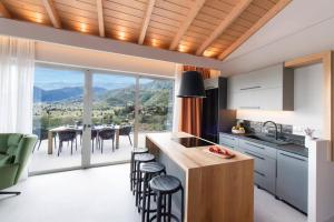 a kitchen with a table and a dining room with a view at Villa Angelou Nidri by Villa Plus in Nydri +12 photos