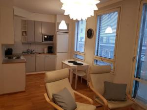 a kitchen and living room with a table and chairs at Kotimaailma - Studio with sauna in center in Turku