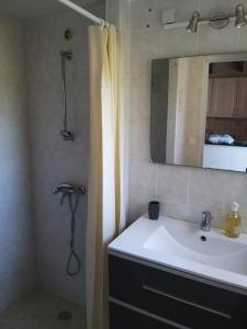 a bathroom with a sink and a shower with a mirror at Maison prés d'Agen in Bon-Encontre