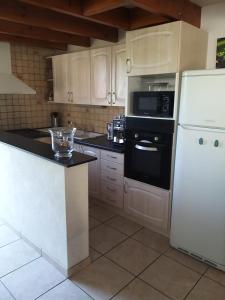 a kitchen with white cabinets and a white refrigerator at Maison prés d'Agen in Bon-Encontre +5 photos