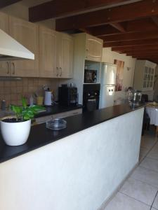 a kitchen with a black counter top and a refrigerator at Maison prés d'Agen in Bon-Encontre
