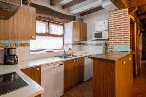 eine Küche mit weißen Geräten und Holzschränken in der Unterkunft Zadorra Etxea Casa in Salvatierra