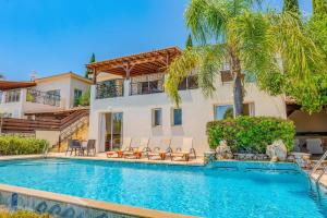 une villa avec piscine et palmiers dans l'établissement Villa Oceana by Villa Plus, à Neo Chorio