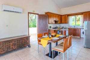 une cuisine avec une table avec des chaises et un réfrigérateur dans l'établissement Villa Oceana by Villa Plus, à Neo Chorio