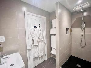 une salle de bain avec douche et lavabo dans l'établissement Mode Cottage, à Lytham St Annes 13 autres photos