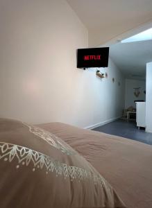 1 cama en una habitación con un cartel en la pared en Studio Saint Denis, en Saint-Denis