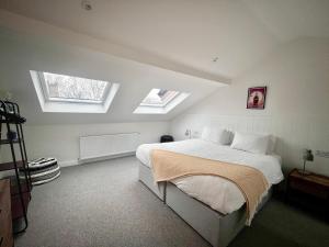 a bedroom with a bed with two skylights at Mode Cottage in Lytham St Annes