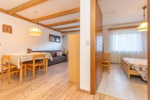 comedor y sala de estar con mesa y sofá en Appartamento Lucia 203, en Vigo di Fassa