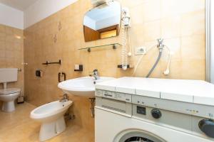 un baño con lavabo e inodoro en Appartamento Lucia 203, en Vigo di Fassa 27 fotos más