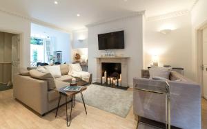 a living room with a couch and a fireplace at Spacious 1 Bed Sloane Square in London