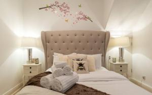 a bedroom with a large bed with towels on it at Spacious 1 Bed Sloane Square in London
