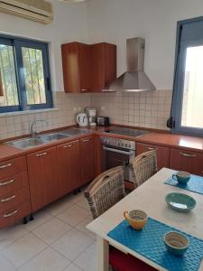 a kitchen with wooden cabinets and a sink and a table at Almyrida Beach Bungalow Sea Front in Chania +19 photos