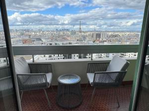 a balcony with chairs and a view of a city at Montparnasse - Vue Tour Eiffel - Balcon in Paris