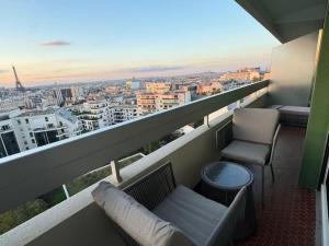 a balcony with a couch and a chair on a building at Montparnasse - Vue Tour Eiffel - Balcon in Paris
