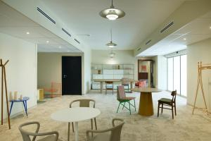 a room with tables and chairs and a kitchen at Hotel des Victoires - Restaurant in Cannes