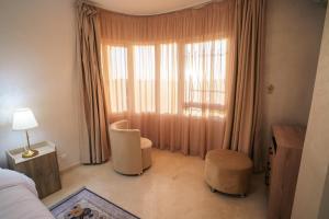 a bedroom with two chairs and a large window at Cozy apartment with stunning view near TGV station in Tangier +48 photos