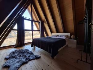 a bedroom with a bed and a large window at Duly Chalet in Kolašin