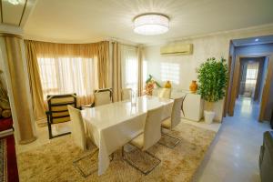 a dining room with a white table and chairs at Cozy apartment with stunning view near TGV station in Tangier