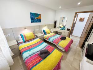 une chambre avec deux lits et un miroir dans l'établissement Casa Los Pinos, à Benissa 64 autres photos