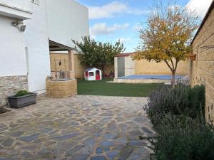 a courtyard with a yard with a white building at Casa rural ValenTina in Almonacid de Toledo