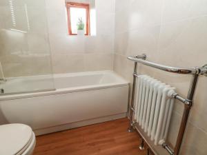 La salle de bains est pourvue d'une baignoire, de toilettes et d'une baignoire. dans l'établissement Brook Cottage, à Hayfield 17 autres photos